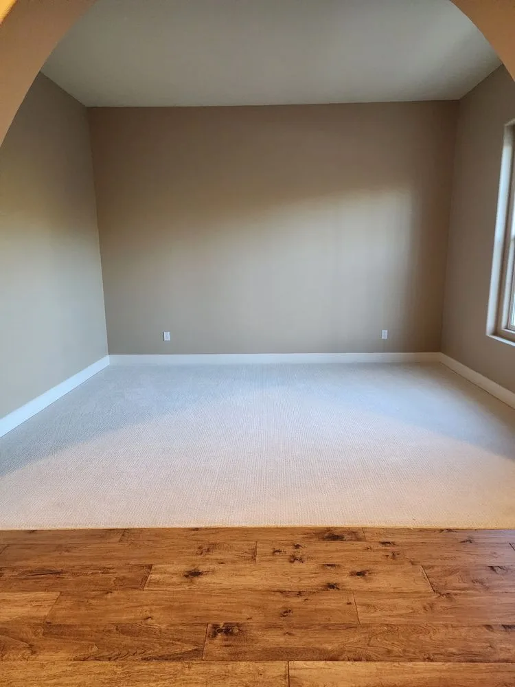 Clean hardwood to carpet flooring transition in a home by The Flooring Design Center