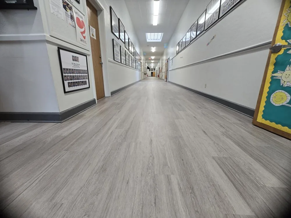 Commercial LVP wood-look plank flooring installed in a school hallway by The Flooring Design Center